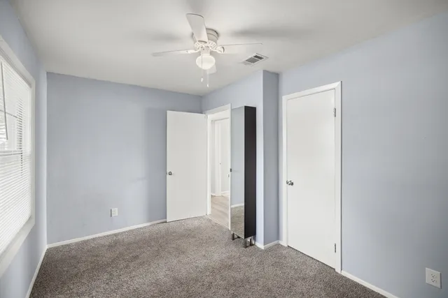 a view of a livingroom with a ceiling fan and window