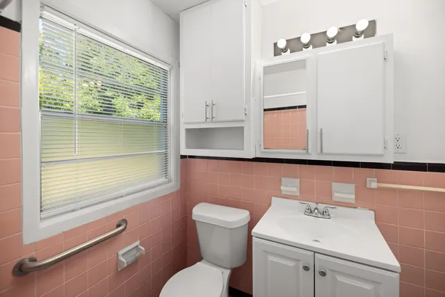 a bathroom with a toilet a sink and a window