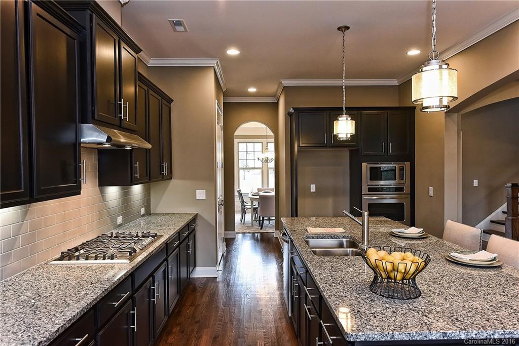 8069 Clems Branch Road Indian Land, SC 29707 - Photo 10 of 24 a kitchen with granite countertop kitchen island stainless steel appliances a sink stove and cabinets