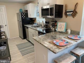 a kitchen with stainless steel appliances granite countertop a sink dishwasher stove microwave and cabinets