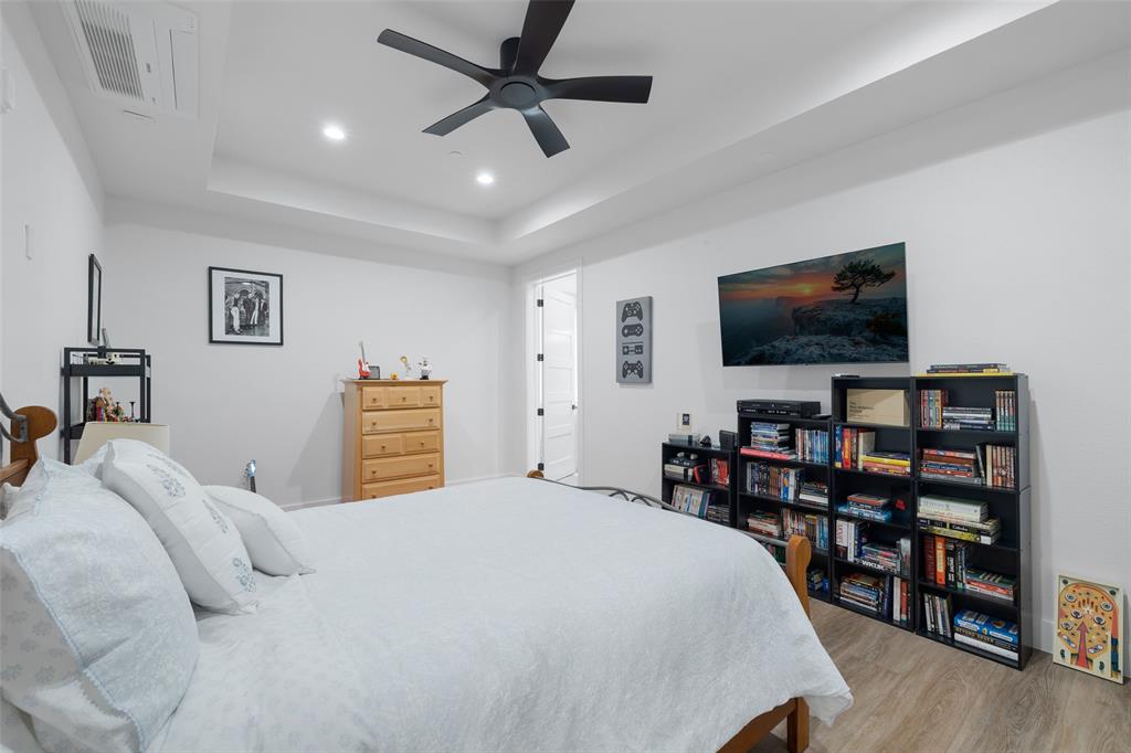 62 Main Street, Unit 200 Colleyville, TX 76034 - Photo 25 of 37 a bedroom with a bed a flat screen tv and a book shelf