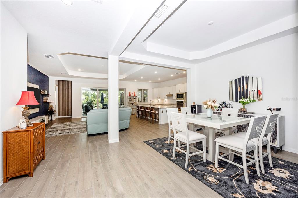12845 Tulum Loop Venice, FL 34293 - Photo 15 of 100 a view of a dining room with furniture one side kitchen view and wooden floor