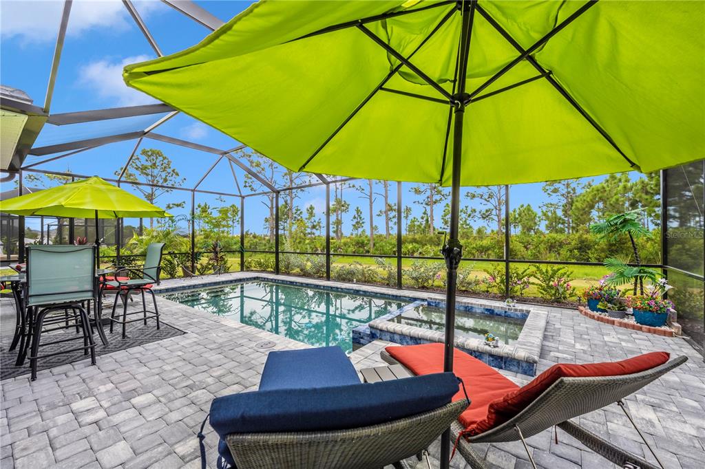 12845 Tulum Loop Venice, FL 34293 - Photo 43 of 100 a view of a swimming pool with a table and chairs under an umbrella
