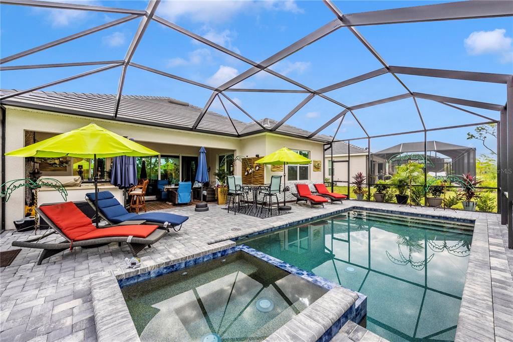 12845 Tulum Loop Venice, FL 34293 - Photo 45 of 100 a view of outdoor kitchen with a table and chairs under an umbrella