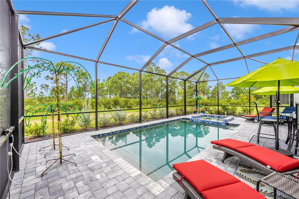 12845 Tulum Loop Venice, FL 34293 - Photo 47 of 100 a view of a patio with a table and chairs under an umbrella