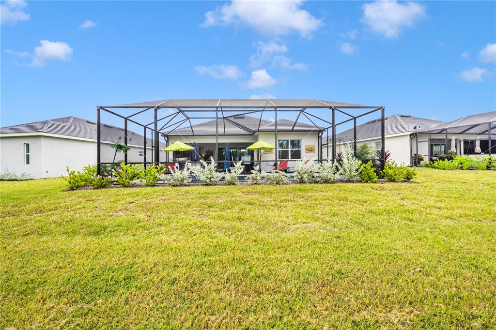 12845 Tulum Loop Venice, FL 34293 - Photo 53 of 100 a view of a swimming pool with a lawn chairs under an umbrella