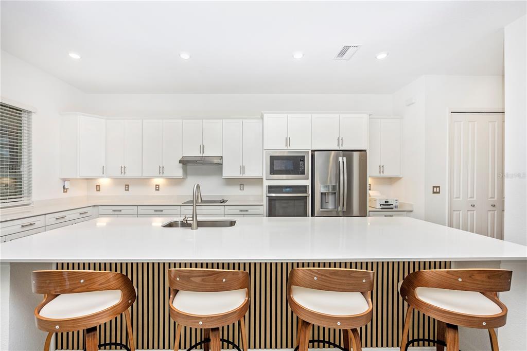 12845 Tulum Loop Venice, FL 34293 - Photo 6 of 100 a kitchen with stainless steel appliances a sink a table and chair