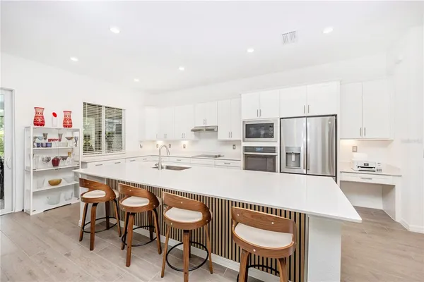 a kitchen with stainless steel appliances a refrigerator sink and microwave