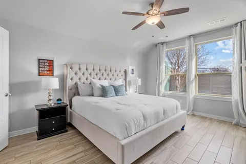 a large bedroom with a bed and wooden floor