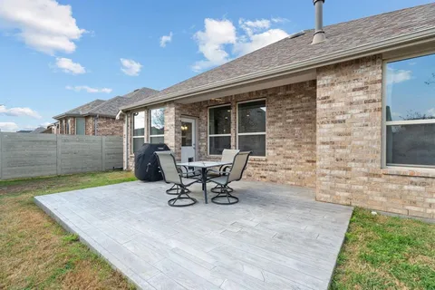a view of a backyard with table and chairs and potted plants