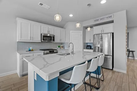 a kitchen with a stove a refrigerator and a dining table