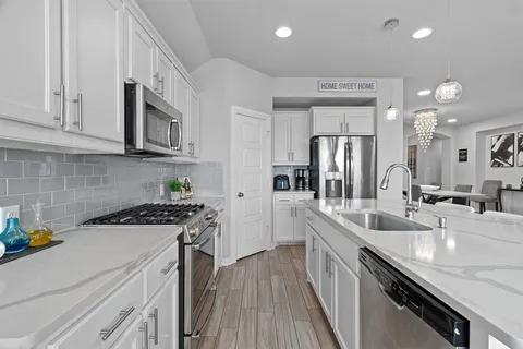 a kitchen with stainless steel appliances granite countertop a sink stove and refrigerator