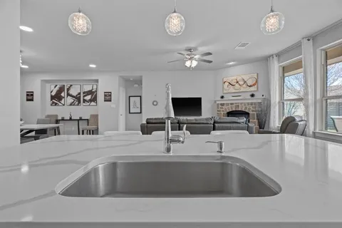 a kitchen with a sink furniture and a flat screen tv