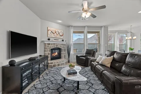 a living room with furniture a flat screen tv and a fireplace