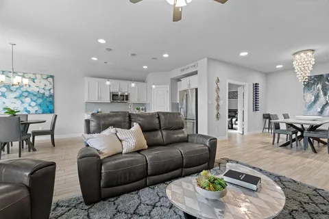 a living room with furniture and a dining table with kitchen view