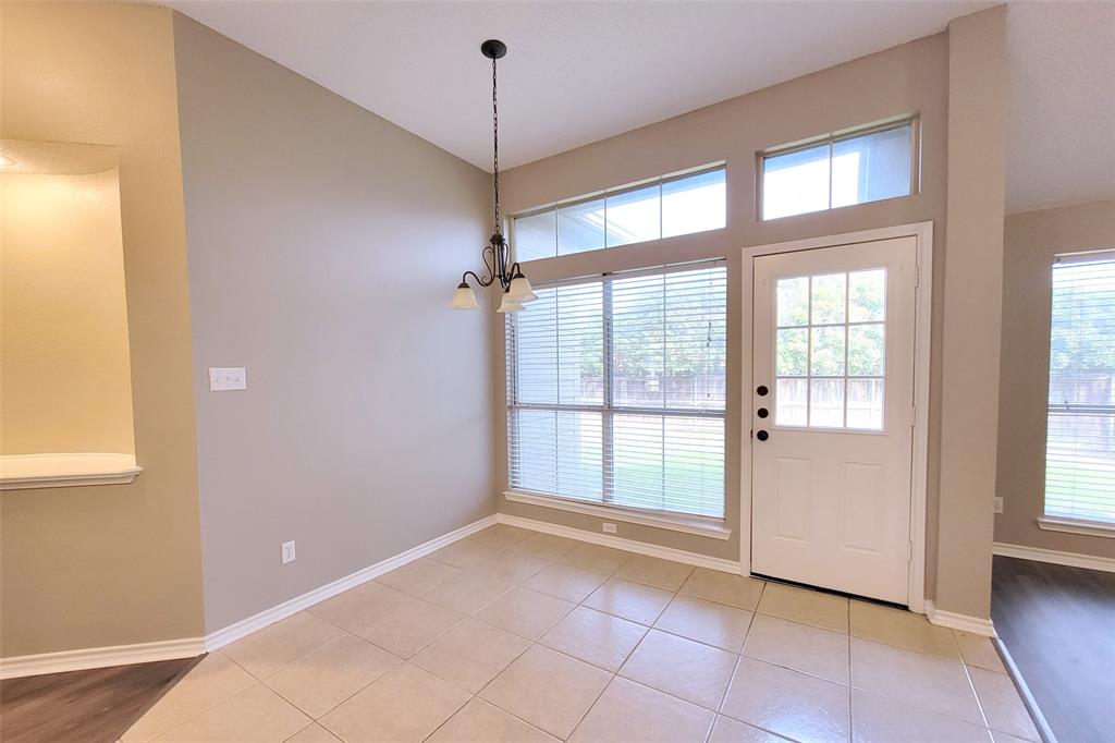 1604 Knoll Ridge Circle Corinth, TX 76210 - Photo 15 of 37 Dining area featuring vaulted ceilings, a chandelier, and tile flooring