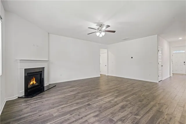 a view of empty room with wooden floor and fireplace