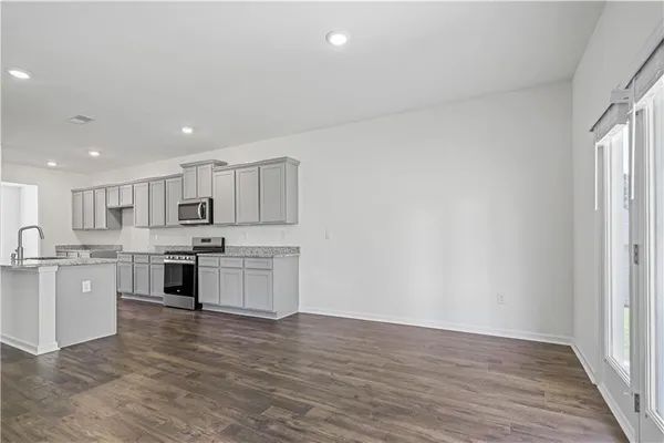 a large kitchen with stainless steel appliances granite countertop a large counter top and a stove top oven