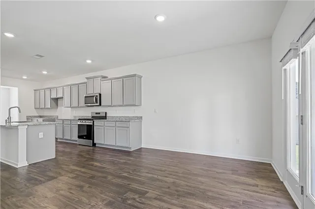 a large kitchen with stainless steel appliances granite countertop a large counter top and a stove top oven