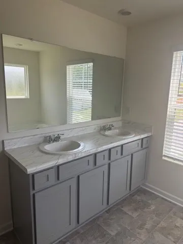 a bathroom with a granite countertop sink and a mirror