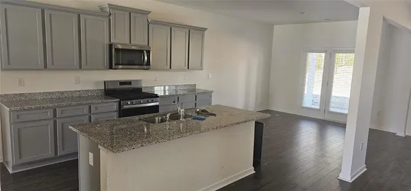 a kitchen with sink a microwave and cabinets