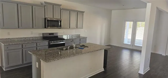 a kitchen with sink a microwave and cabinets