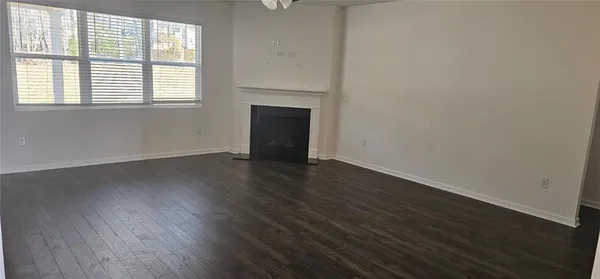 an empty room with wooden floor and a window