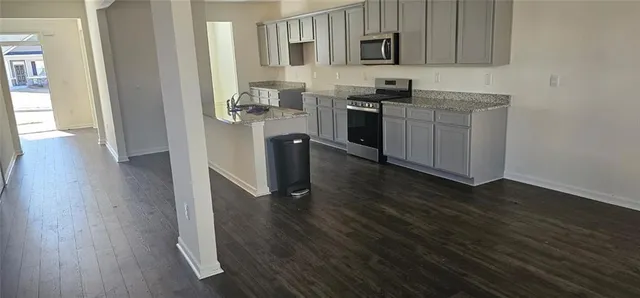 a kitchen with stainless steel appliances granite countertop a stove a sink and a refrigerator