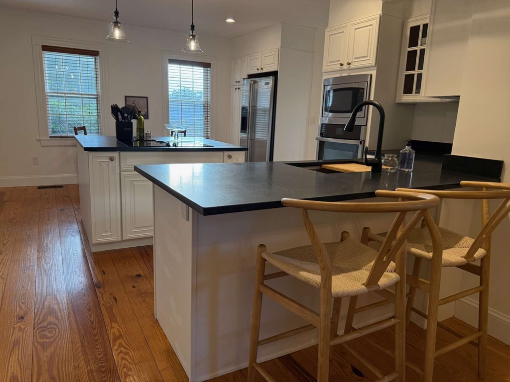 105 Elm Street, Unit A Andover, MA 01810 - Photo 12 of 40 a kitchen with a table chairs refrigerator and sink