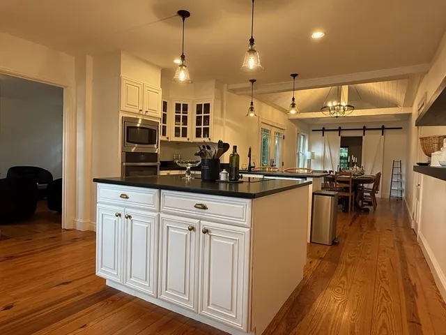 a kitchen with stainless steel appliances granite countertop a sink a stove a refrigerator and island