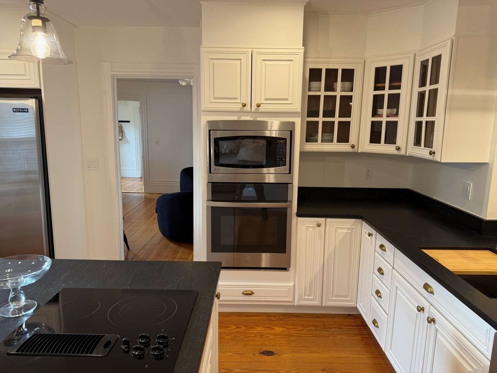 105 Elm Street, Unit A Andover, MA 01810 - Photo 16 of 40 a kitchen with stainless steel appliances granite countertop a stove and a refrigerator