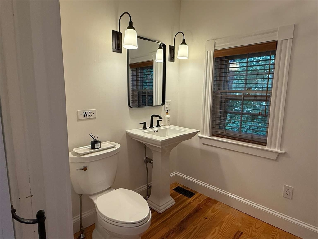 105 Elm Street, Unit A Andover, MA 01810 - Photo 19 of 40 a bathroom with a toilet a sink and a mirror