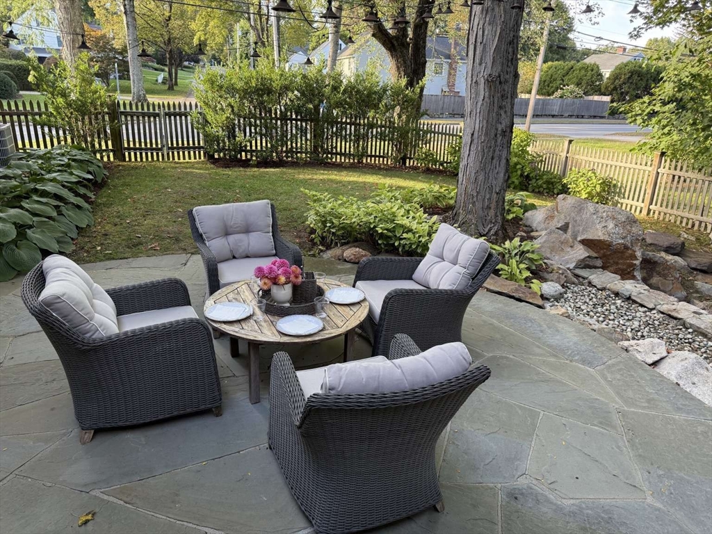 105 Elm Street, Unit A Andover, MA 01810 - Photo 33 of 40 a view of a patio with couches chairs and a yard with wooden fence