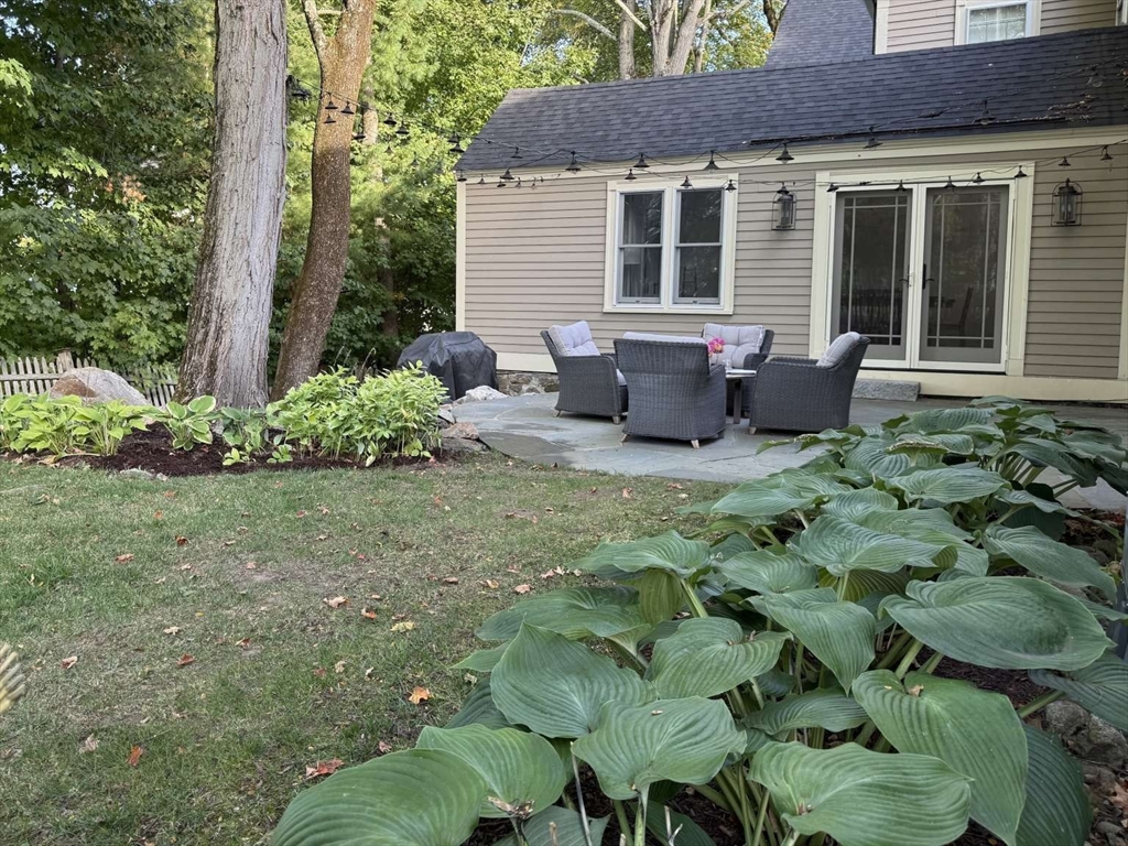 105 Elm Street, Unit A Andover, MA 01810 - Photo 34 of 40 a view of a house with backyard sitting area and garden