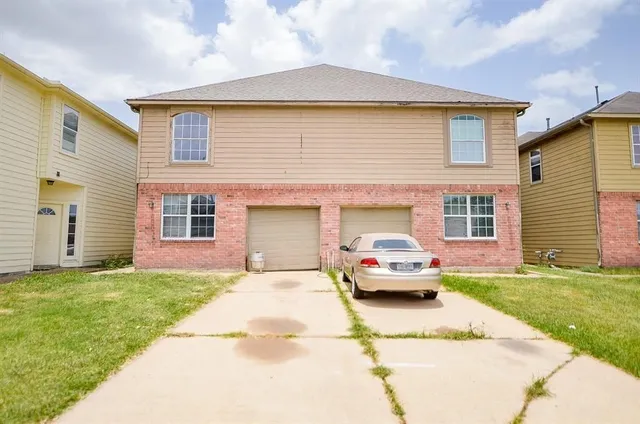 a front view of a house with a garden and trees