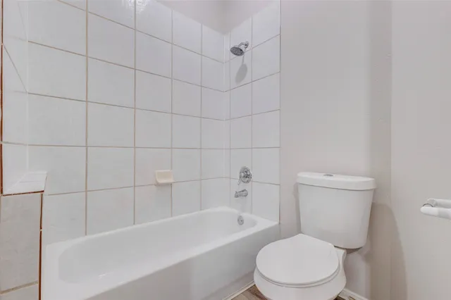 a white toilet and tub sitting next to a bathroom sink