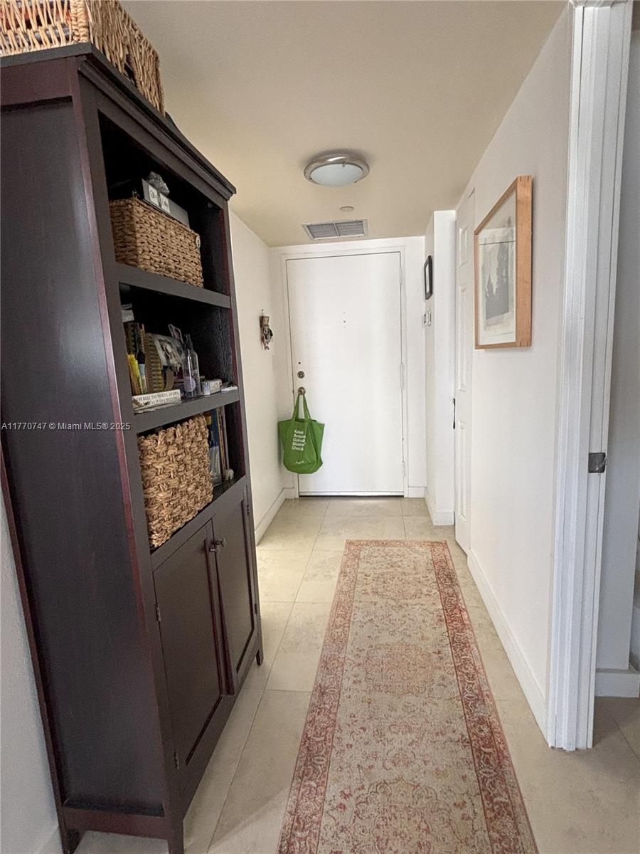 1901 Brickell Avenue, Unit B2310 Miami, FL 33129 - Photo 8 of 16 a view of hallway with chair and frames on the wall