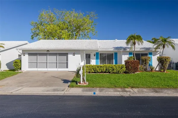 a front view of a house with a garden and plants