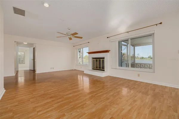a view of an empty room with a chandelier fan