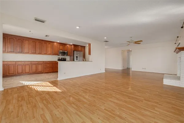 an empty room with windows and chandelier fan