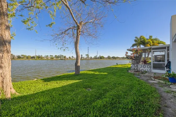 an aerial view of residential houses with outdoor space and lake view