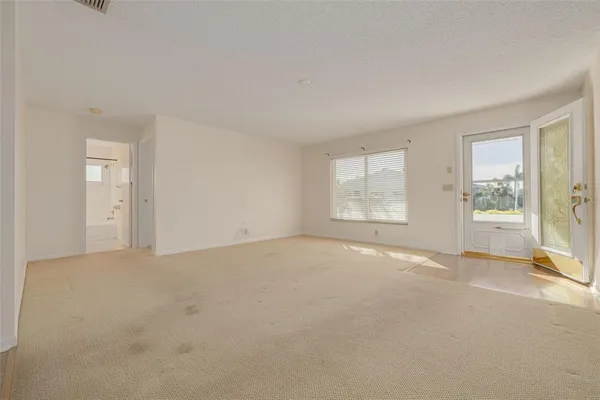 an empty room with wooden floor a fireplace and windows