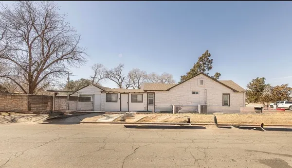 a view of a white house with a big yard and large trees