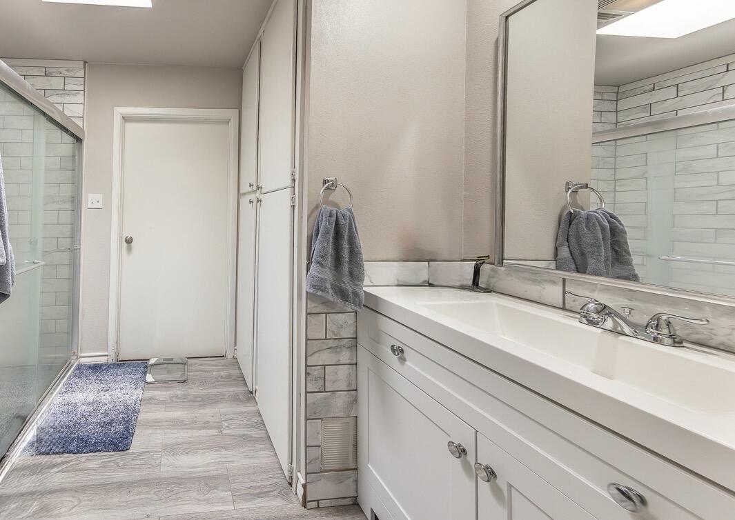 2301 27th Street Lubbock, TX 79411 - Photo 12 of 22 a bathroom with a sink and a mirror