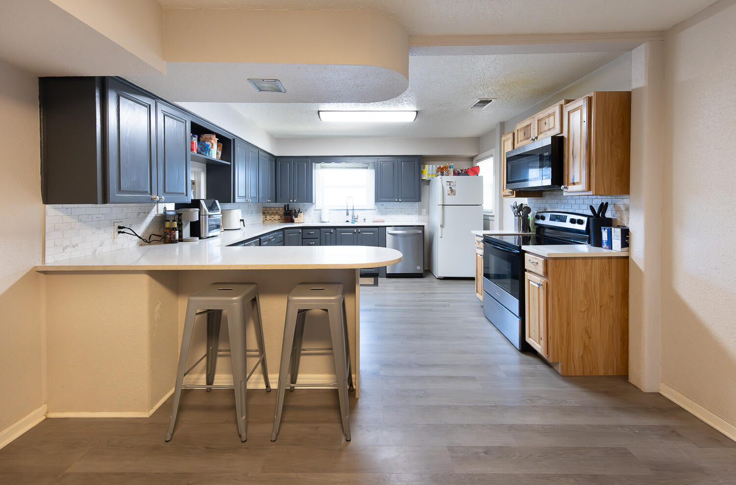 2301 27th Street Lubbock, TX 79411 - Photo 5 of 22 a kitchen with stainless steel appliances granite countertop a table chairs sink and cabinets