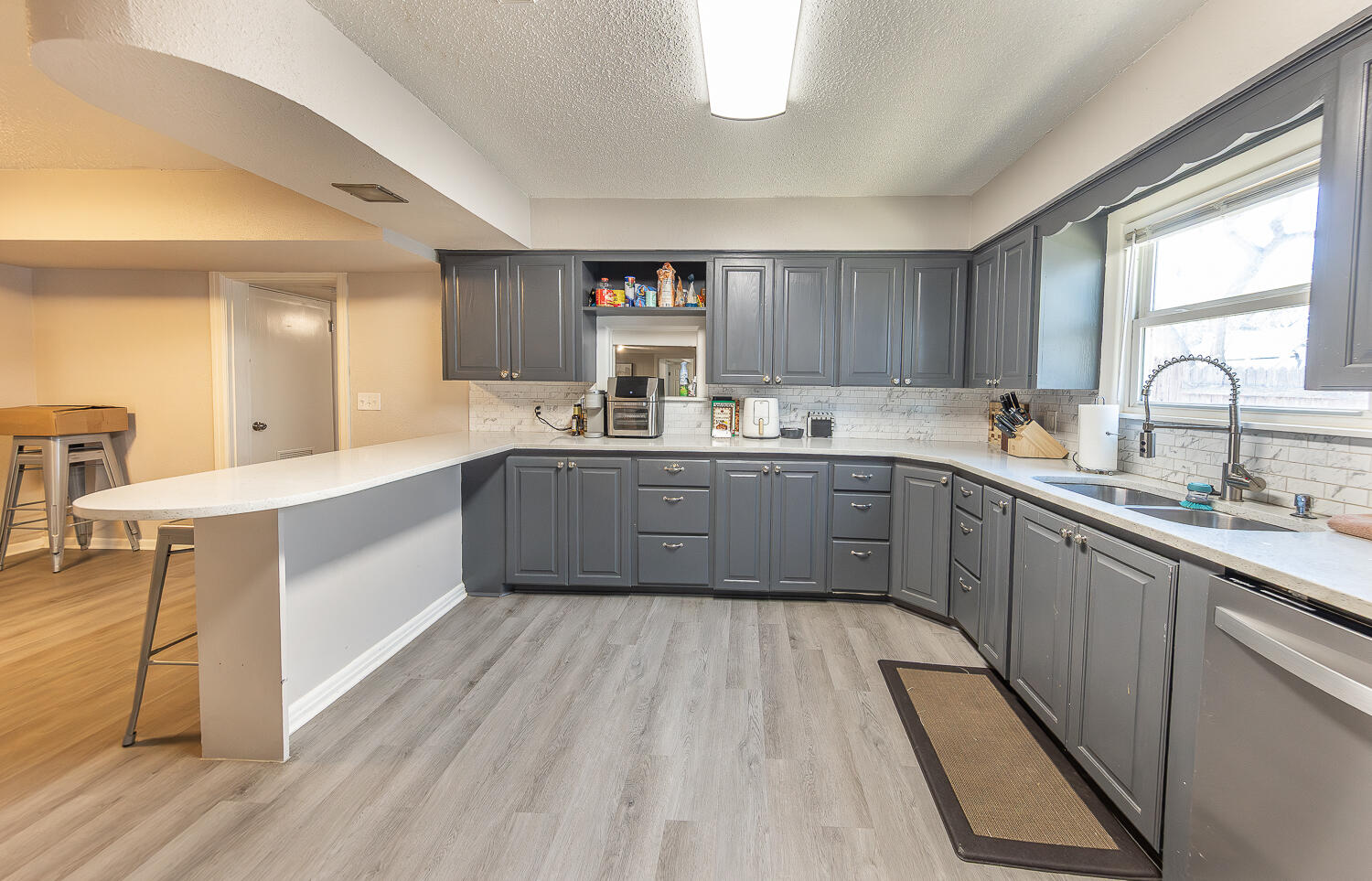 2301 27th Street Lubbock, TX 79411 - Photo 6 of 22 a large kitchen with a sink window and cabinets
