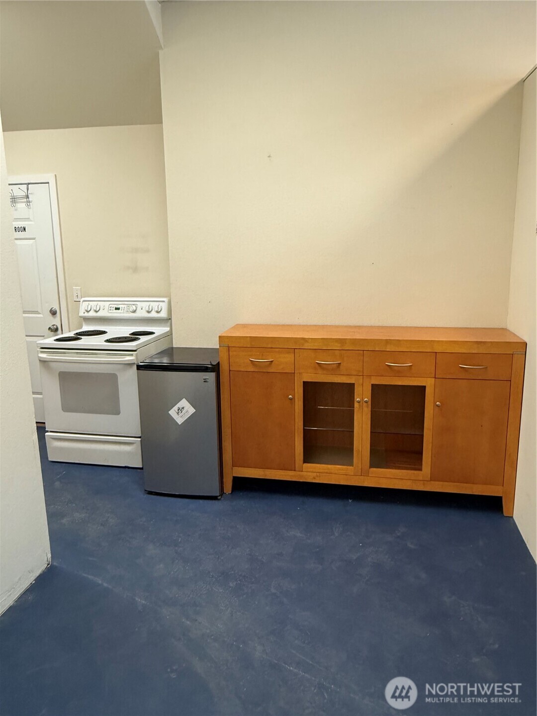 3837 Aurora Avenue North, Unit 100 Seattle, WA 98103 - Photo 5 of 6 a view of an empty room with kitchen stove and wooden floor