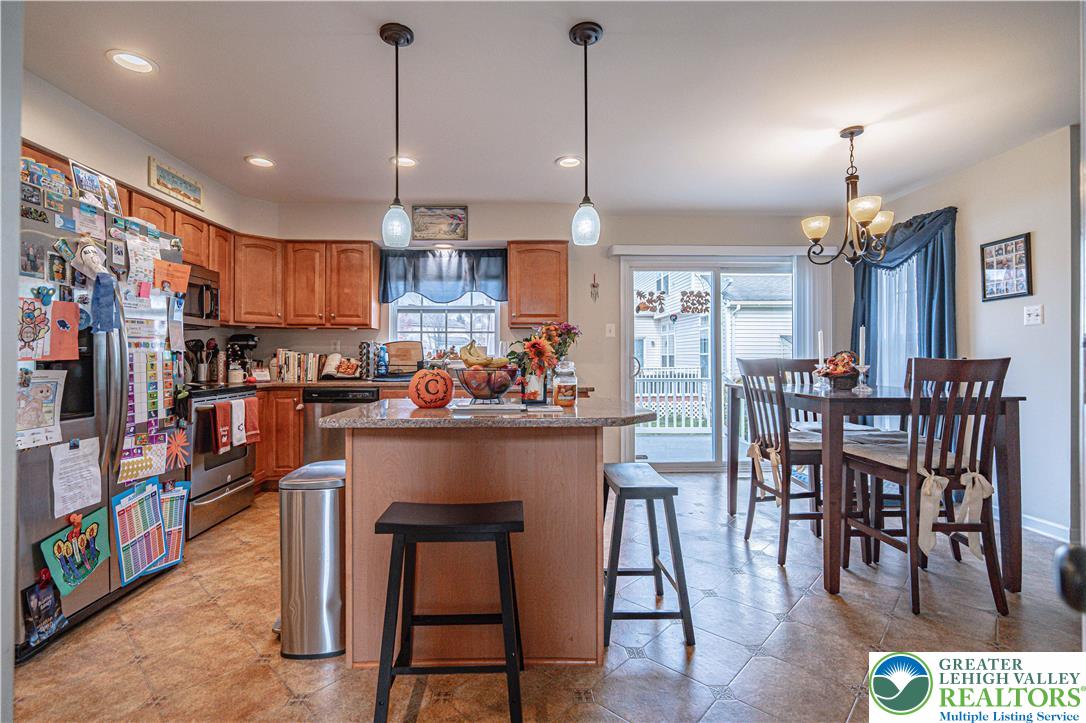1120 Tyler Way Bethlehem, PA 18017 - Photo 12 of 67 a kitchen with stainless steel appliances kitchen island granite countertop a dining table chairs and a refrigerator