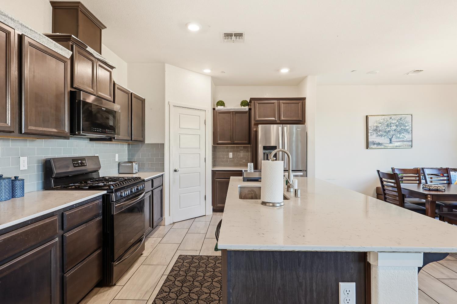 2367 Explorador Drive Merced, CA 95340 - Photo 13 of 42 a kitchen with stainless steel appliances a stove sink microwave and refrigerator