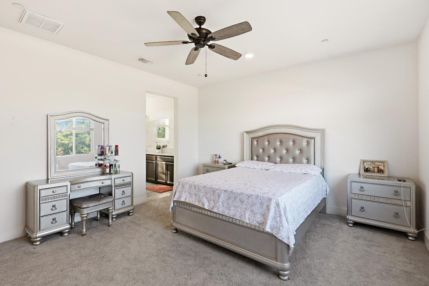 2367 Explorador Drive Merced, CA 95340 - Photo 20 of 42 a bedroom with a bed and a chandelier